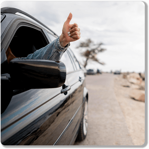 Happy customer giving thumbs up from car